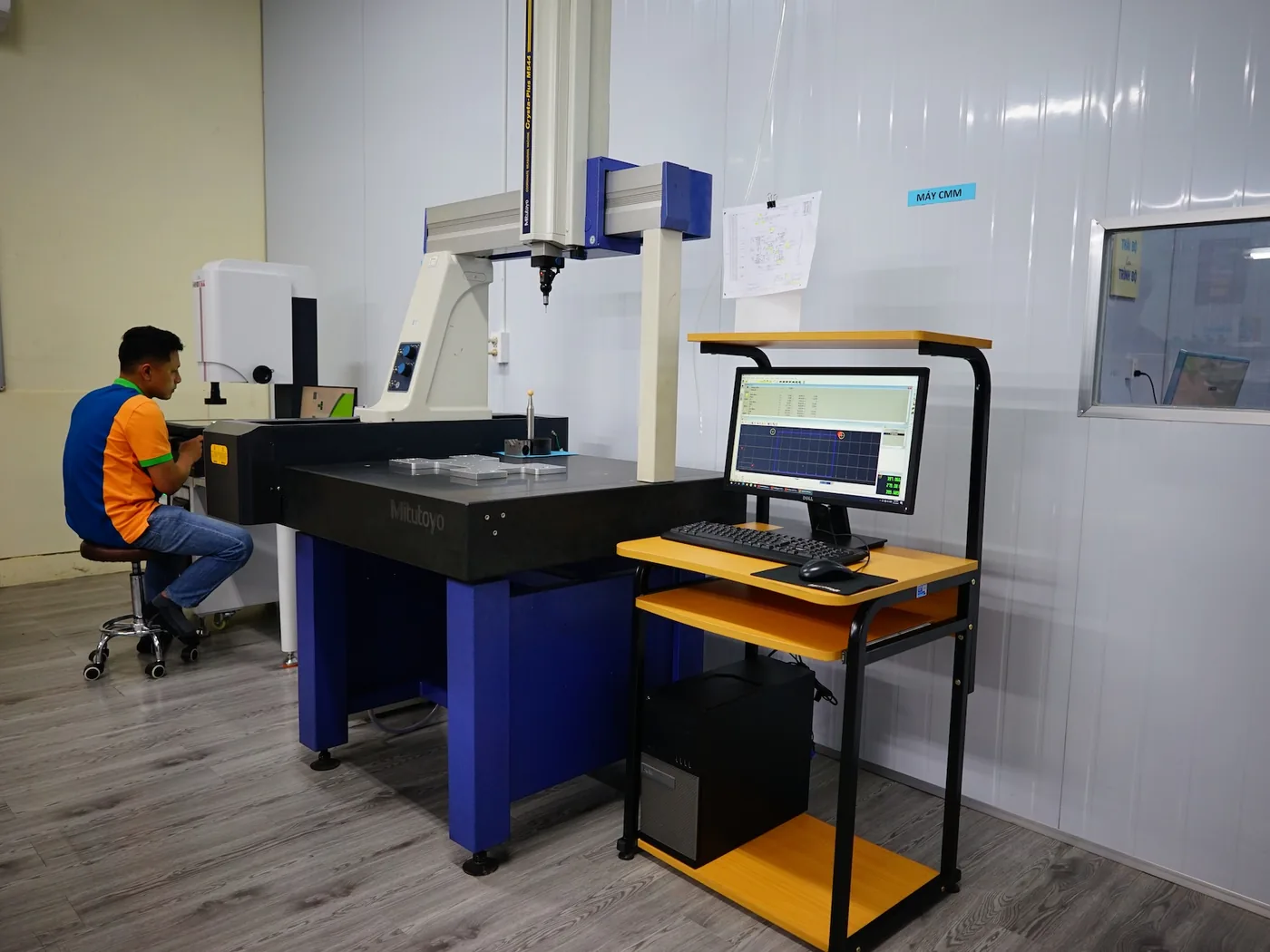 Quality engineer operating a coordinate measuring machine in the inspection room at Far East High Tech