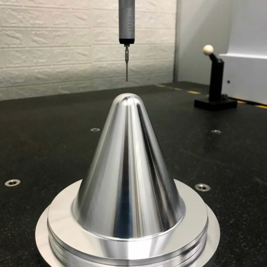 Turned aluminium cone being measured on the CMM with a Renishaw probe