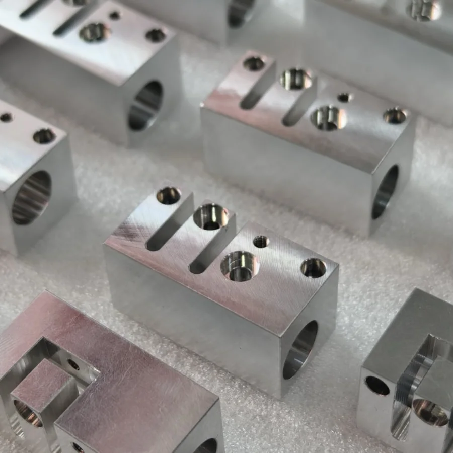 Batch of machined aluminium slide blocks with cross-drilled bores